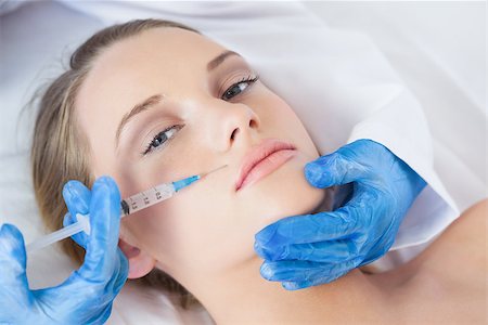 Surgeon making injection above lips on cute woman lying on operating table Stock Photo - Budget Royalty-Free & Subscription, Code: 400-07060361