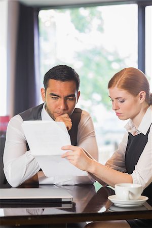 simsearch:400-07137867,k - Serious business partners working together in a cafe on documents Fotografie stock - Microstock e Abbonamento, Codice: 400-07060754