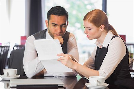 simsearch:400-07137867,k - Serious business team working together in a cafe and going over documents Fotografie stock - Microstock e Abbonamento, Codice: 400-07060753