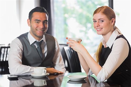 simsearch:400-07137867,k - Business people having coffee and looking at camera in a cafe Fotografie stock - Microstock e Abbonamento, Codice: 400-07060762