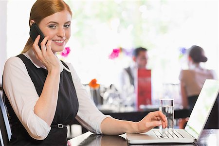 simsearch:400-07137867,k - Businesswoman calling on phone and looking at camera in a restaurant Fotografie stock - Microstock e Abbonamento, Codice: 400-07060797