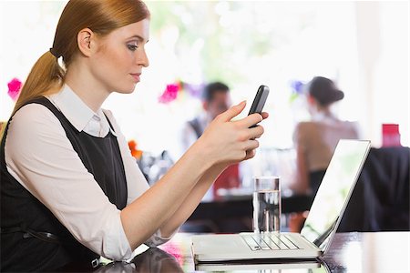 simsearch:400-07137867,k - Concentrated businesswoman sending a text in a restaurant Fotografie stock - Microstock e Abbonamento, Codice: 400-07060798