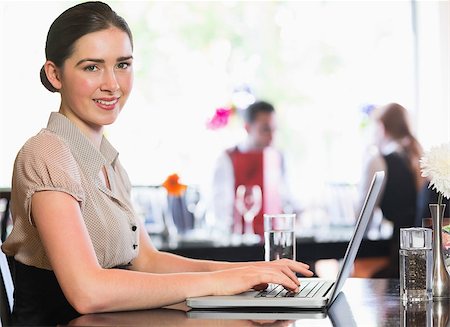 restaurant work teenager - Attractive businesswoman working on laptop smiling at camera in a cafe Photographie de stock - Aubaine LD & Abonnement, Code: 400-07060814