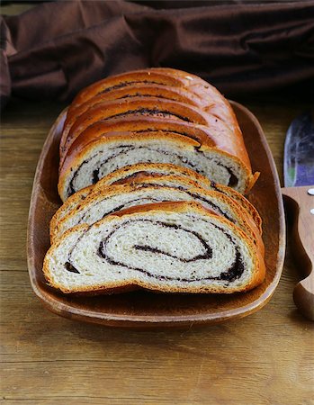 Biscuit roll with poppy seeds on a wooden plate Stock Photo - Budget Royalty-Free & Subscription, Code: 400-07061195