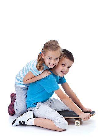 portrait of boy sitting on skateboard - Happy kids playing with skateboard and wrestling on the floor - isolated Stock Photo - Budget Royalty-Free & Subscription, Code: 400-07086796