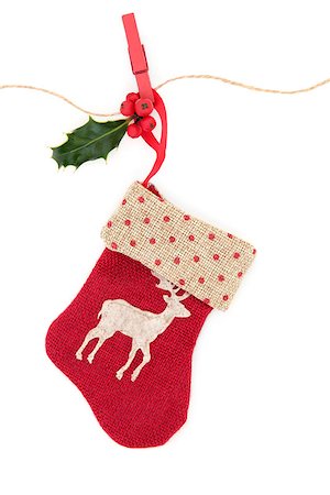 Christmas reindeer stocking with holly berry leaf sprig on a string line with peg over white background. Photographie de stock - Aubaine LD & Abonnement, Code: 400-07086940