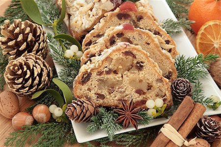 Stollen christmas cake with mandarin oranges, nuts, cinnamon spice, pinecones, mistletoe and winter greenery. Stock Photo - Budget Royalty-Free & Subscription, Code: 400-07086955