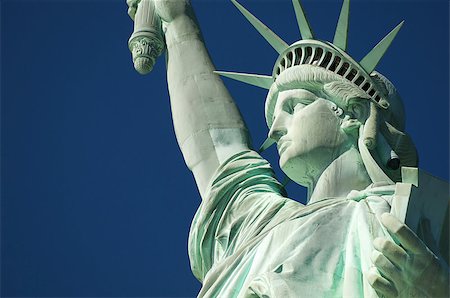 estatua de la libertad - Statue of Liberty close-up profile with crown and book against blue sky Foto de stock - Super Valor sin royalties y Suscripción, Código: 400-07087096