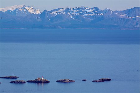 simsearch:400-07087598,k - Lighthouse on tiny rocky islets near Lofoten islands with mountainous norwegian coast in the background Stock Photo - Budget Royalty-Free & Subscription, Code: 400-07087815