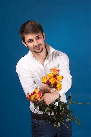 simsearch:400-07097695,k - Man with bouquet of red roses. On blue background. Stock Photo - Budget Royalty-Free & Subscription, Code: 400-07087871