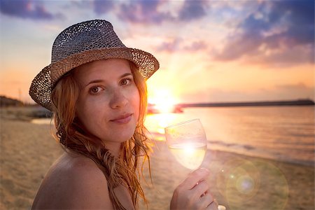 simsearch:400-07324083,k - People collection: beautiful lady in hat with glass of wine on the beach Stock Photo - Budget Royalty-Free & Subscription, Code: 400-07088171