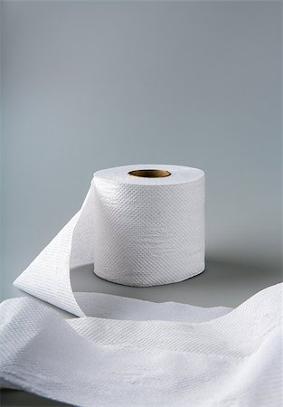 a roll of toilet paper lying on a gray background Fotografie stock - Microstock e Abbonamento, Codice: 400-07088553