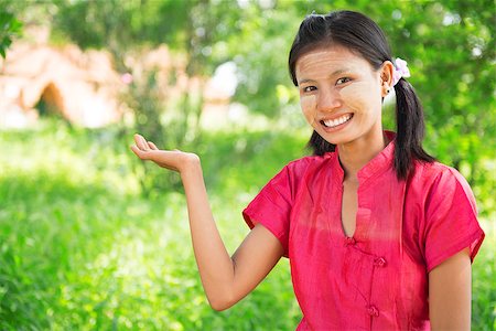 photographic portraits poor people - Portrait of happy smiling beautiful young traditional Myanmar girl showing empty palm, welcoming pose at outdoor. Stock Photo - Budget Royalty-Free & Subscription, Code: 400-07094835