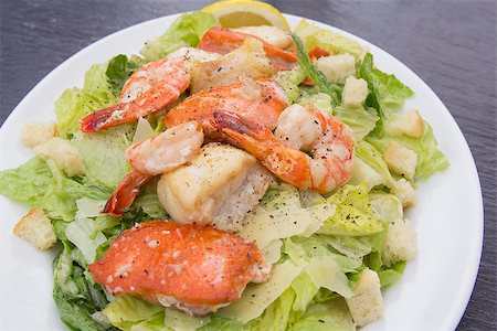 Caesar Salad with Prawns Salmon White Cod Fish Croutons Lemon and Cracked Black Pepper Closeup Stock Photo - Budget Royalty-Free & Subscription, Code: 400-07095329