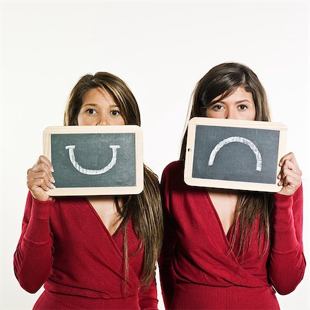 sibling sad - studio shot portrait on isolated background of two sisters twin women friends expressing positivity and negativity in the same time Stock Photo - Budget Royalty-Free & Subscription, Code: 400-07095506