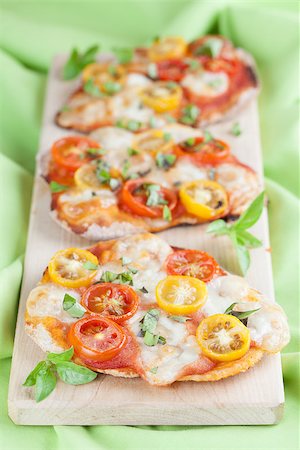 Mini pizzas with mozzarella, colorful cherry tomatoes and basil Stock Photo - Budget Royalty-Free & Subscription, Code: 400-07095945