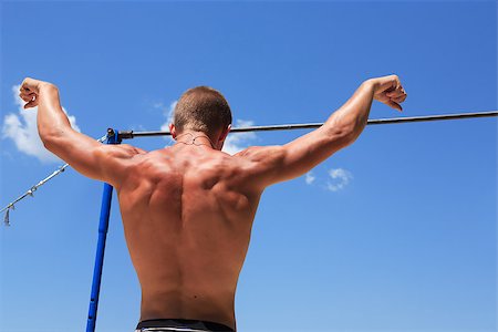 pull up man - Young strong athlete standing before horizontal bar against blue sky Stock Photo - Budget Royalty-Free & Subscription, Code: 400-07095981