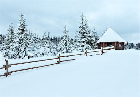 summerhouse - Wooden summerhouse on winter hill top and fir forest behind . Cloudy day. Photographie de stock - Aubaine LD & Abonnement, Code: 400-07096047