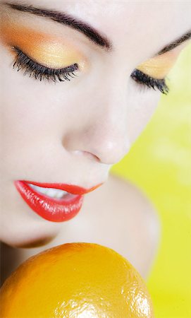 simsearch:400-07097858,k - beautiful caucasian woman portrait holding a mandarine studio on yellow background Foto de stock - Super Valor sin royalties y Suscripción, Código: 400-07097617