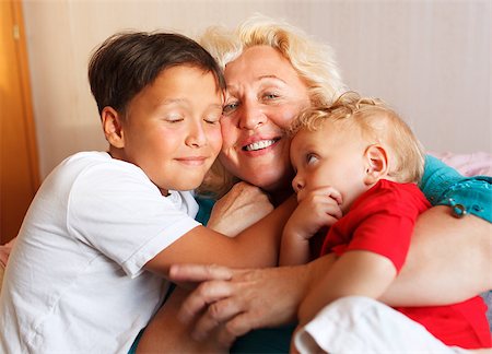 simsearch:400-08955829,k - Happy grandmother hugging with her grandchildren at home Stock Photo - Budget Royalty-Free & Subscription, Code: 400-07099007