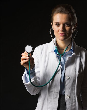 simsearch:400-07099882,k - Doctor woman using stethoscope on black background Photographie de stock - Aubaine LD & Abonnement, Code: 400-07099868