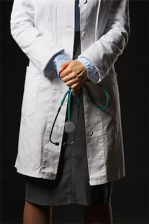 simsearch:400-07099882,k - Closeup on stethoscope in hand of doctor woman isolated on black Photographie de stock - Aubaine LD & Abonnement, Code: 400-07099869