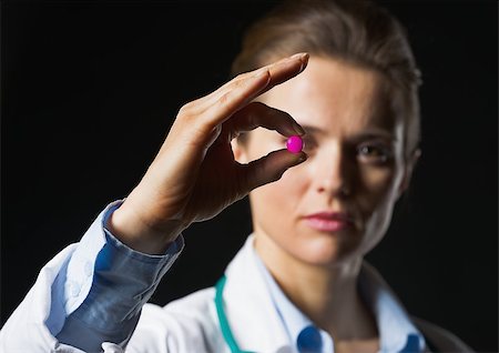 simsearch:400-07099832,k - Closeup on pill in hand of doctor woman on black background Stock Photo - Budget Royalty-Free & Subscription, Code: 400-07099876
