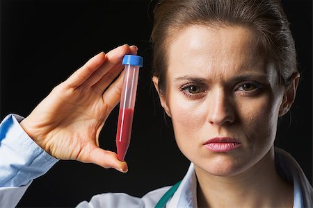 simsearch:400-07099882,k - Doctor woman showing test tube isolated on black Photographie de stock - Aubaine LD & Abonnement, Code: 400-07099889