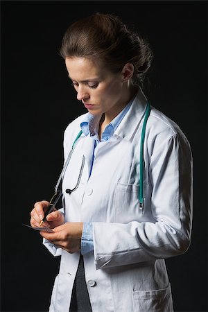 simsearch:400-07099882,k - Doctor woman writing prescription isolated on black Photographie de stock - Aubaine LD & Abonnement, Code: 400-07099882
