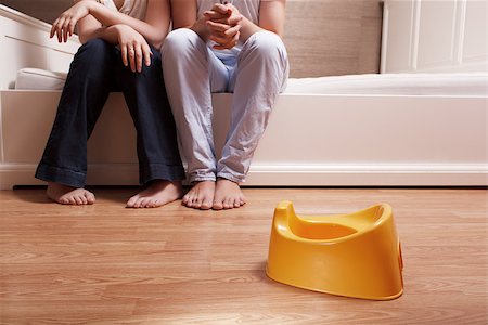 educazione all'uso del vaso - Young parents are sitting on the bed and thinking how to teach kid to use children's pot. Fotografie stock - Microstock e Abbonamento, Codice: 400-07092739