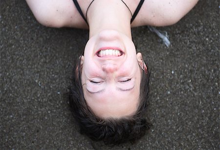 Closeup portrait of smiling young girl lying on sand near sea Foto de stock - Super Valor sin royalties y Suscripción, Código: 400-07093276