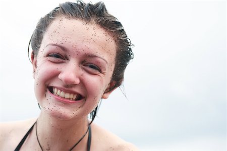 Portrait of smiling teenage girl with sand on her face Foto de stock - Super Valor sin royalties y Suscripción, Código: 400-07093278