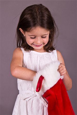 Little girl getting a gift from her Christmas stocking Photographie de stock - Aubaine LD & Abonnement, Code: 400-07104648