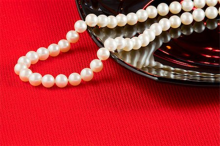 simsearch:400-04778993,k - Pearl necklace and black ceramic dish on a red tablecloth Stock Photo - Budget Royalty-Free & Subscription, Code: 400-07104660