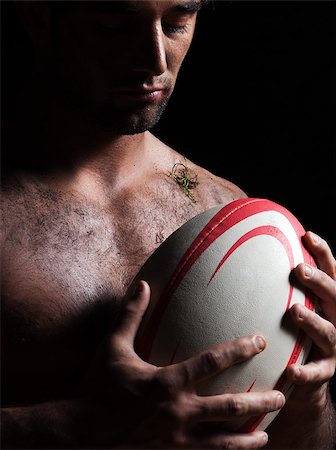 one caucasian sexy topless man portrait hugging a rugby ball on studio black background Stock Photo - Budget Royalty-Free & Subscription, Code: 400-07100718