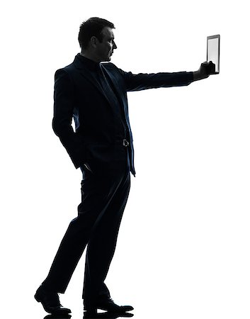 full body man standing alone holding tablet - one caucasian business man holding digital tablet   in silhouette on white background Stock Photo - Budget Royalty-Free & Subscription, Code: 400-07101544