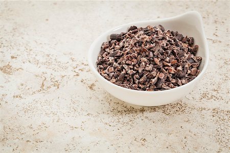 ponta de caneta - small ceramic bowl of  raw cacao nibs  against a ceramic tile background with a copy space Foto de stock - Royalty-Free Super Valor e Assinatura, Número: 400-07102659