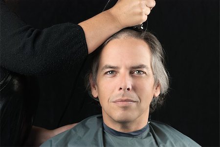 Close-up of a serious man looking to camera while his long hair is shaved off for a cancer fundraiser. Photographie de stock - Aubaine LD & Abonnement, Code: 400-07115677