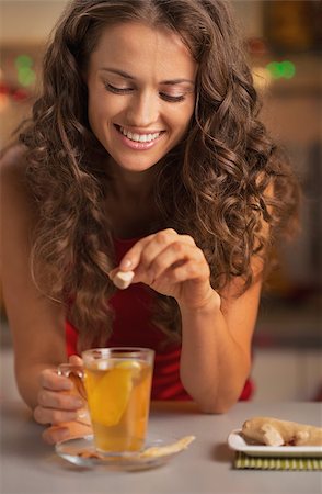 pic of drinking celebration for new year - Smiling young woman adding cane sugar cube in ginger tea Stock Photo - Budget Royalty-Free & Subscription, Code: 400-07116187