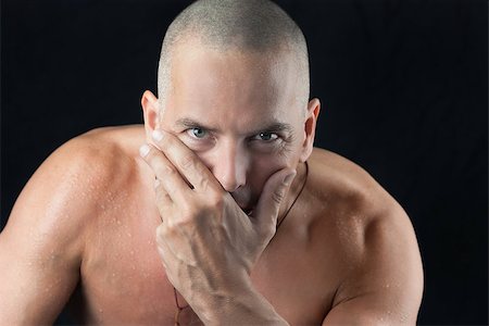 Close-up of a confident man looking to camera, shiirtless, shaved head Photographie de stock - Aubaine LD & Abonnement, Code: 400-07111795