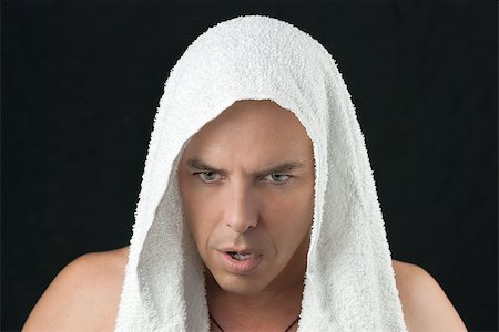 Close-up of a intense man thinking, workout towel over head, looking down. Stock Photo - Budget Royalty-Free & Subscription, Code: 400-07111796