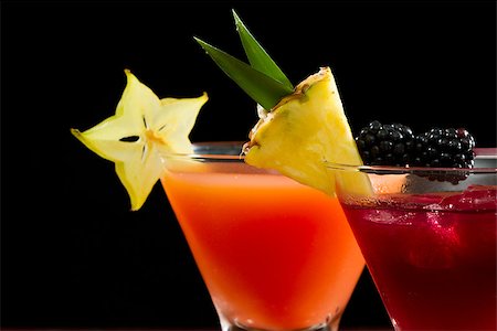 simsearch:400-06797125,k - cocktails served in  stemless martini glasses garnished with a pineapple slice, blackberries and star fruit Stock Photo - Budget Royalty-Free & Subscription, Code: 400-07112362
