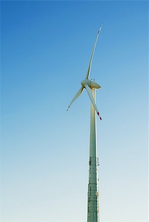 A wind engine in front of a blue summer sky. Vertical Foto de stock - Royalty-Free Super Valor e Assinatura, Número: 400-07124508