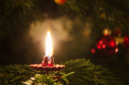 A candle on a christmas tree with decoration in the background. Foto de stock - Royalty-Free Super Valor e Assinatura, Número: 400-07124938