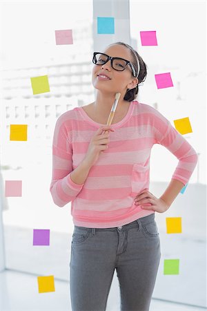 Attractive artist holding a brush and looking at camera in her creative office Stock Photo - Budget Royalty-Free & Subscription, Code: 400-07126695