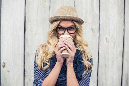 simsearch:400-04807075,k - Smiling fashionable blonde drinking coffee outdoors on wooden background Foto de stock - Super Valor sin royalties y Suscripción, Código: 400-07126953