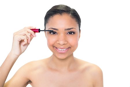 Happy young dark haired model applying mascara on white background Photographie de stock - Aubaine LD & Abonnement, Code: 400-07127073