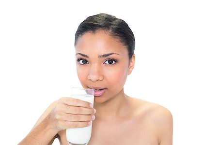 Charming young dark haired model drinking milk on white background Foto de stock - Super Valor sin royalties y Suscripción, Código: 400-07127091