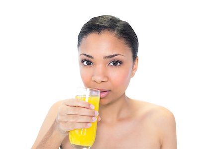 Beautiful young dark haired model drinking orange juice on white background Foto de stock - Super Valor sin royalties y Suscripción, Código: 400-07127093
