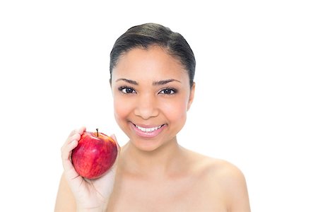 Delighted young dark haired model holding a red apple on white background Photographie de stock - Aubaine LD & Abonnement, Code: 400-07127104